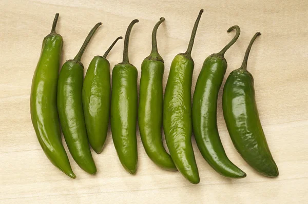 Groene chili peppers in rij — Stockfoto