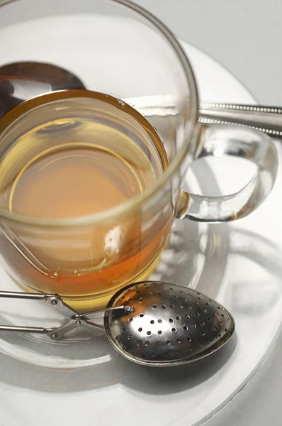 Taza de té con colador en platillo — Foto de Stock