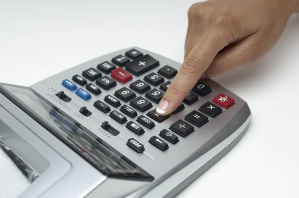 Крупный план пальца с помощью цифрового калькулятора — стоковое фото