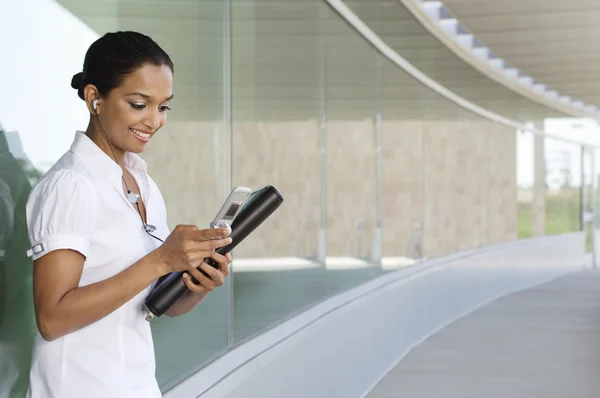 Mujer de negocios escuchando música en el teléfono celular — Foto de Stock