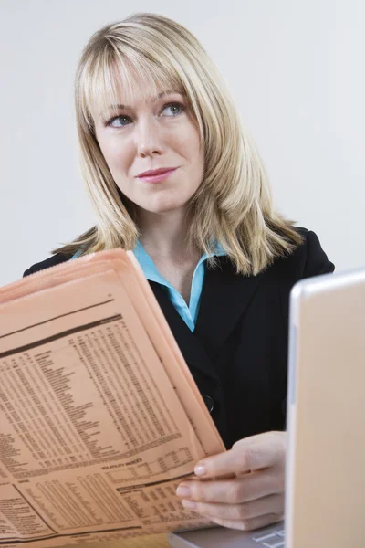 Geschäftsfrau mit Zeitung und Laptop — Stockfoto