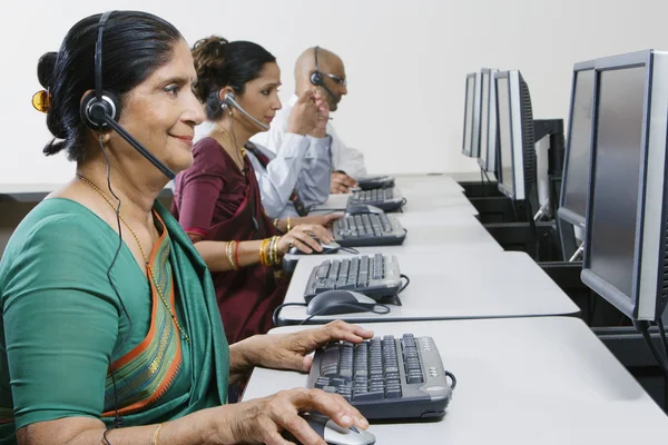 Vrouwelijke klant dienst exploitant werken met collega's op kantoor — Stockfoto