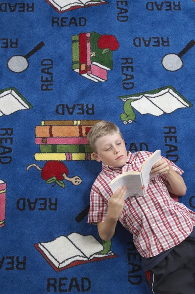 Chlapec čtení knih na podlaze — Stock fotografie