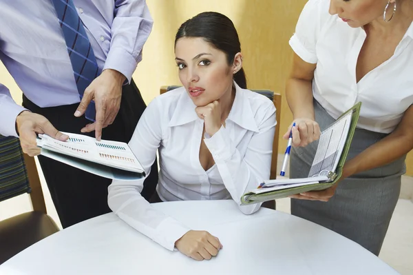 Empresaria con colegas mostrando bloc de notas a ella —  Fotos de Stock