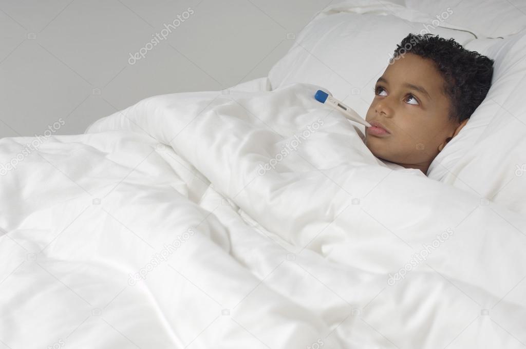 Boy With Thermometer Lying In Bed