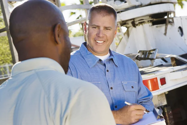 Mechanic Looking At Client While Writing On Clipboard — Stock Photo, Image