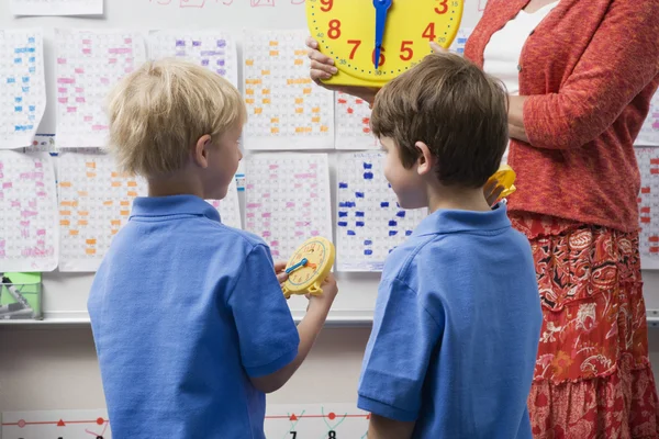 Schooljongens leren tijd te vertellen — Stockfoto