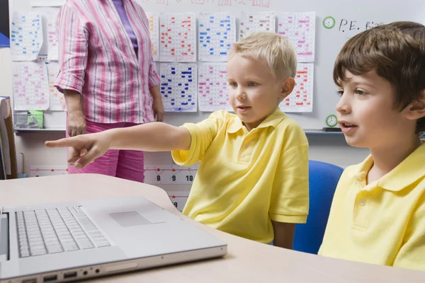 Schooljongen wijzend op laptop — Stockfoto