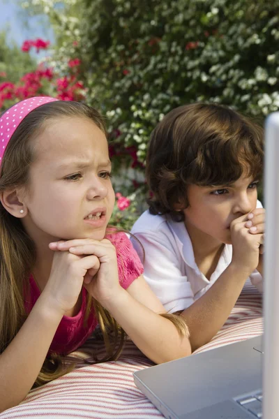 Niños pequeños mirando un ordenador portátil — Foto de Stock