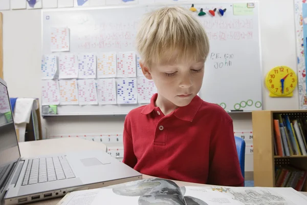 Schooljongen bestuderen met behulp van een laptop — Stockfoto