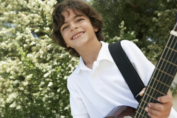 Mały chłopiec gra na gitarze. — Zdjęcie stockowe