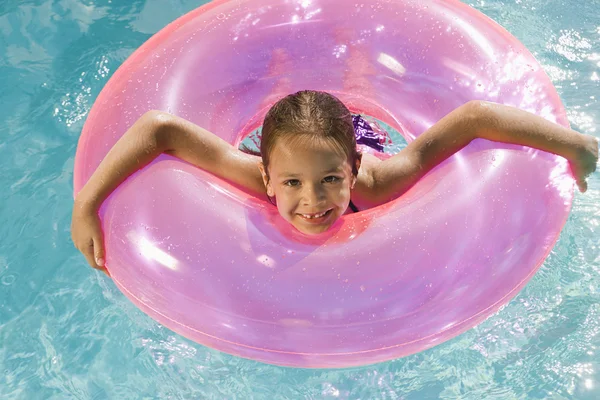 Fille à l'intérieur rose flotteur Tube dans piscine — Photo