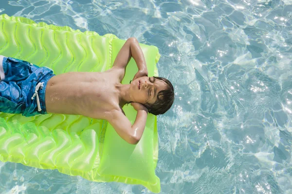Jongen drijvend in zwembad — Stockfoto