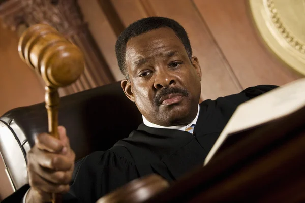Soudce klepe kladívkem v soudní síni — Stock fotografie