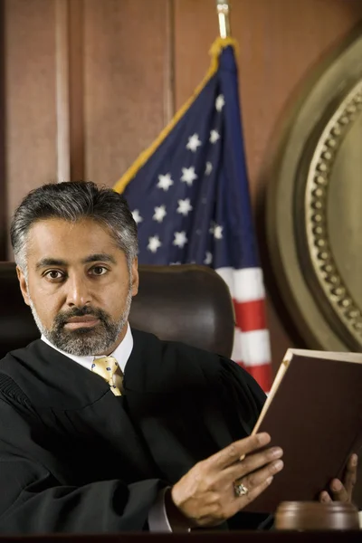 Juez sentado con libro de leyes — Foto de Stock