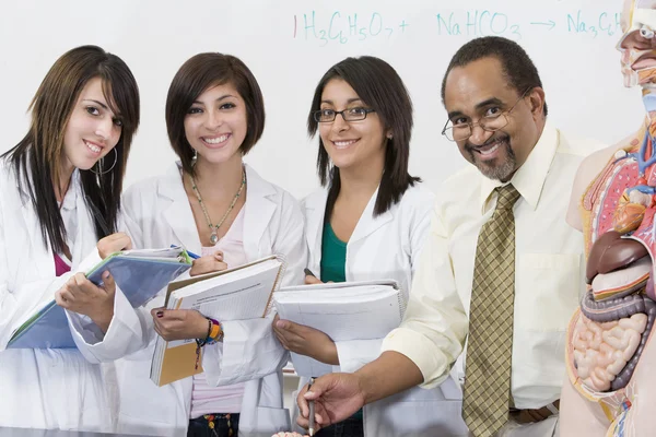 Professor med kvinnliga studenter i science lab — Stockfoto