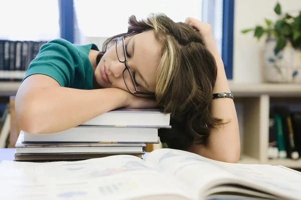 Estudante do ensino médio dormindo na biblioteca — Fotografia de Stock