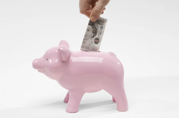Insertar mano libra moneda en Piggybank —  Fotos de Stock