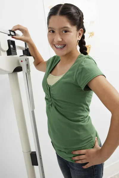 Menina em pé na máquina de pesagem — Fotografia de Stock