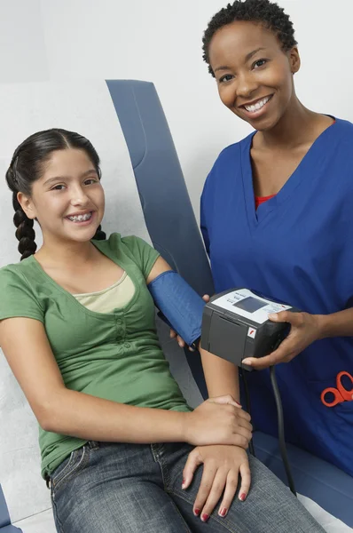 Doktor kontrol kızın kan basıncı — Stok fotoğraf