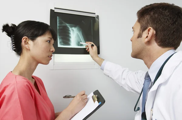 Médico y enfermera discutiendo resultados de rayos X — Foto de Stock