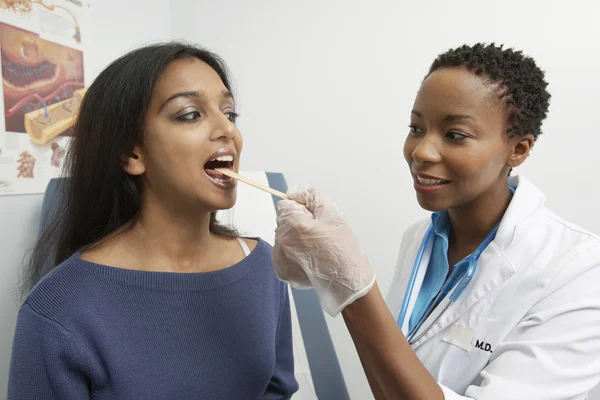 Médecin avec dépresseur de langue examinant le patient — Photo