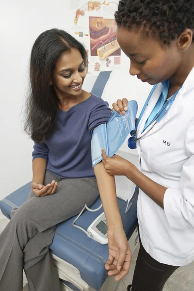 Läkare kontrollera patientens blodtryck — Stockfoto