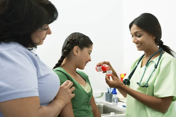 Ženský lékař dává medicíně dívkou — Stock fotografie