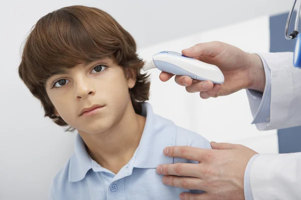 Médico tomando a temperatura do menino — Fotografia de Stock