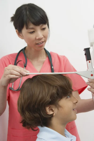 Médico medindo a altura de um menino — Fotografia de Stock