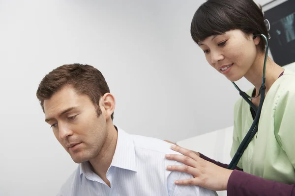 Médico examinando paciente usando estetoscopio — Foto de Stock