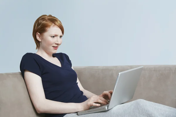 Молодая женщина с удивлением смотрит на ноутбук — стоковое фото