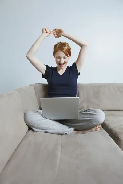 Dizüstü bilgisayar kullanan muzaffer genç kadın — Stok fotoğraf