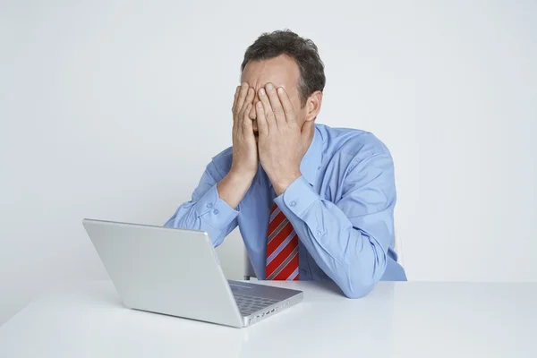 Depressief zakenman met laptop aan balie — Stockfoto