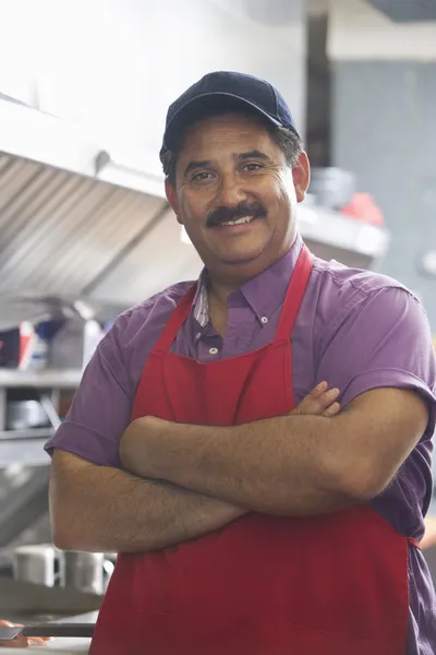 Zelfverzekerde man met armen gekruist in keuken — Stockfoto