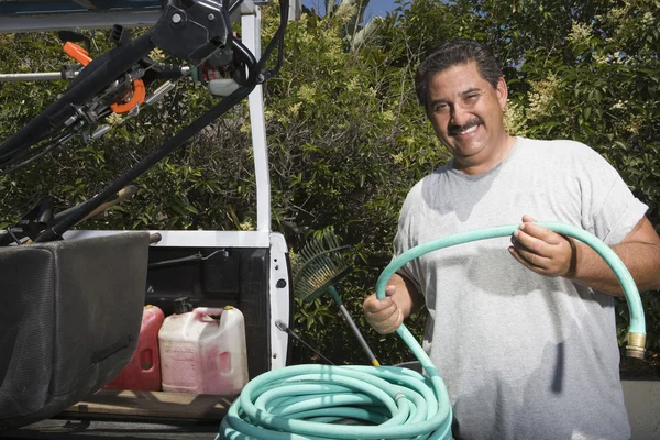 Man bedrijf slang in tuin — Stockfoto