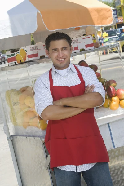 Vendedor ambulante De pie junto al puesto de ensaladas de frutas — Foto de Stock