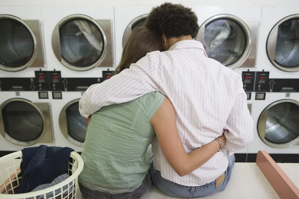 Pareja sentada en la lavandería — Foto de Stock