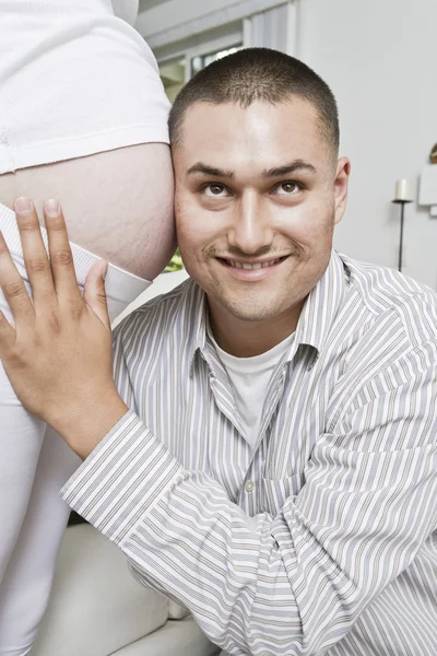 Homem com cabeça no abdômen da mulher grávida — Fotografia de Stock