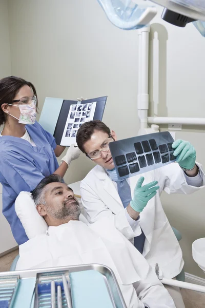歯科医は患者にレントゲン検査報告書を説明します。 — ストック写真