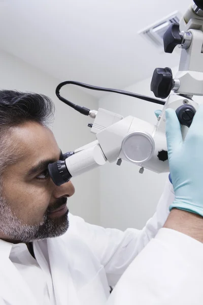 Mikroskop ile Asya erkek diş hekimi — Stok fotoğraf