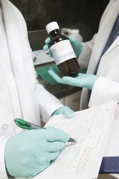 Medical staff with drug bottle and documents — Stock Photo, Image