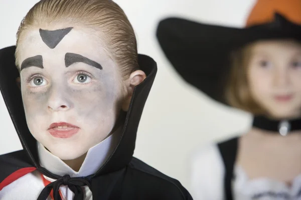 Niño vistiendo traje de Drácula con chica en segundo plano — Foto de Stock