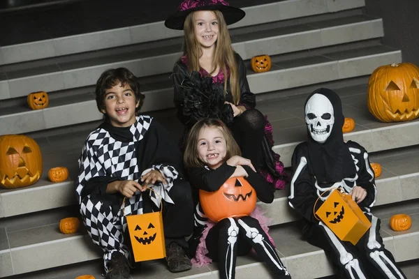 Barnen bär halloween kostymer på stegen — Stockfoto