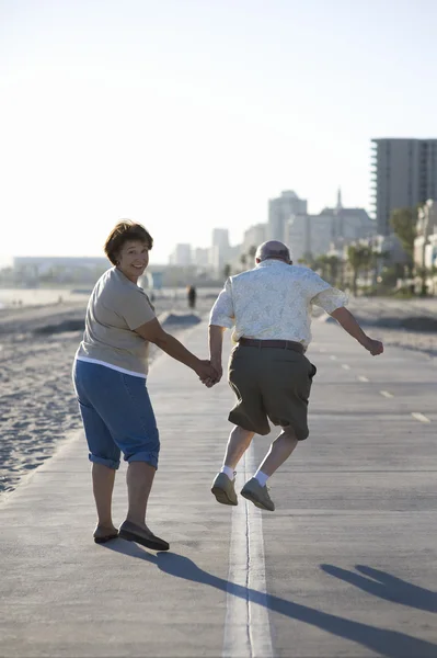 Seniorenpaar auf Fußweg am Strand — Stockfoto