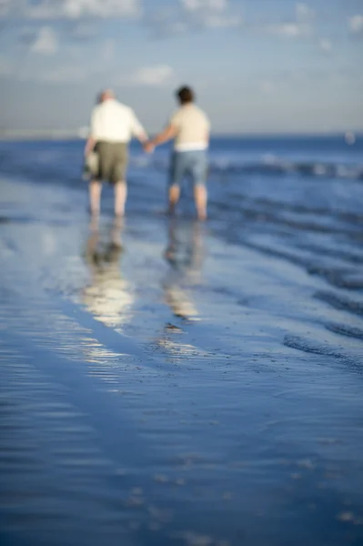 Pareja de ancianos caminando en la playa — Foto de Stock