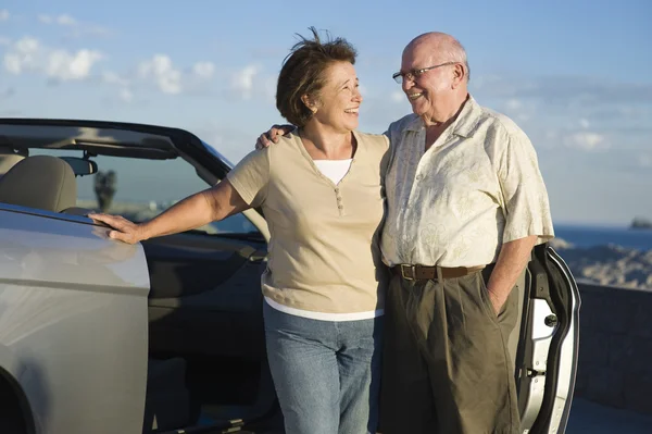 Äldre par stående tillsammans med bil — Stockfoto