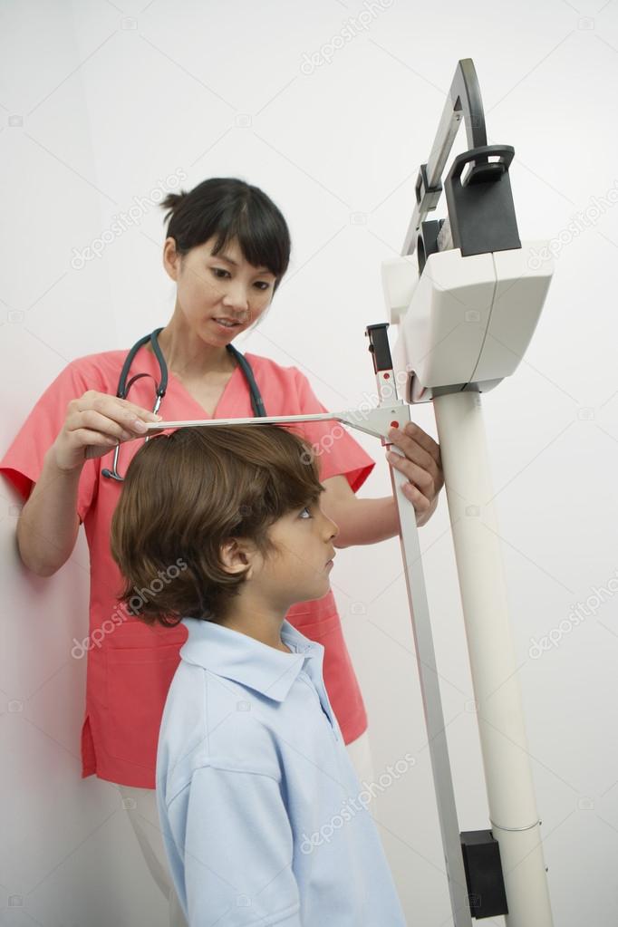 Doctor Measuring Height Of Boy