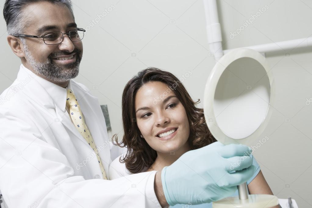 Dentist And Patient Using Mirror