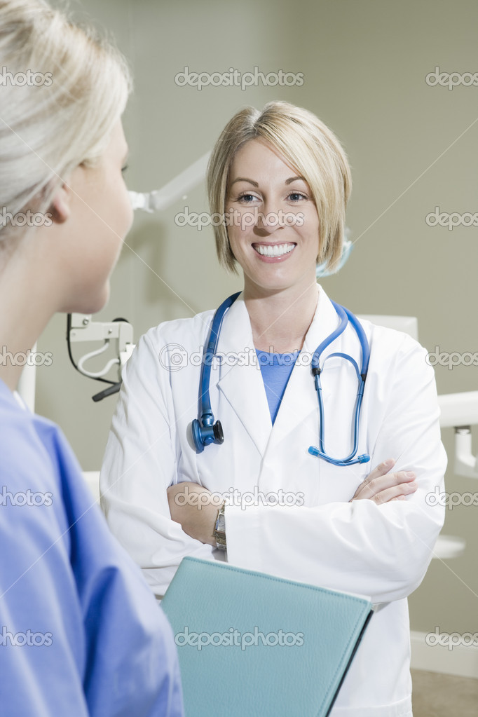 Dentist With Arms Crossed Looking At Nurse